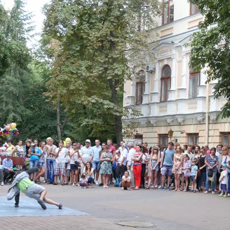 boy breakdances at city street