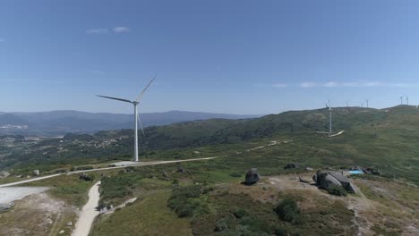 Luftaufnahme-Eines-Hauses-In-Den-Bergen-Mit-Windmühlen