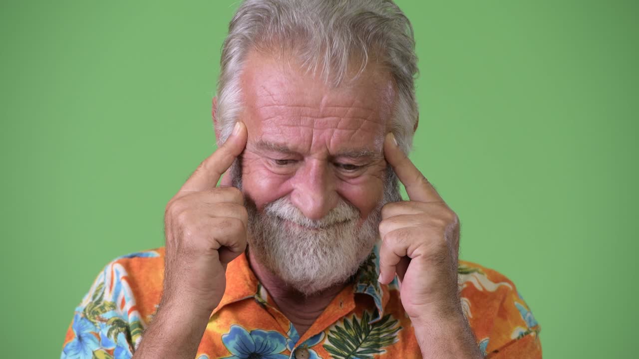 hombre turista barbudo y guapo listo para las vacaciones contra un fondo verde