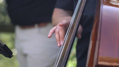 contrabajo de primer plano en cámara lenta, músico tocando el contrabajo en pie en una boda en el jardín