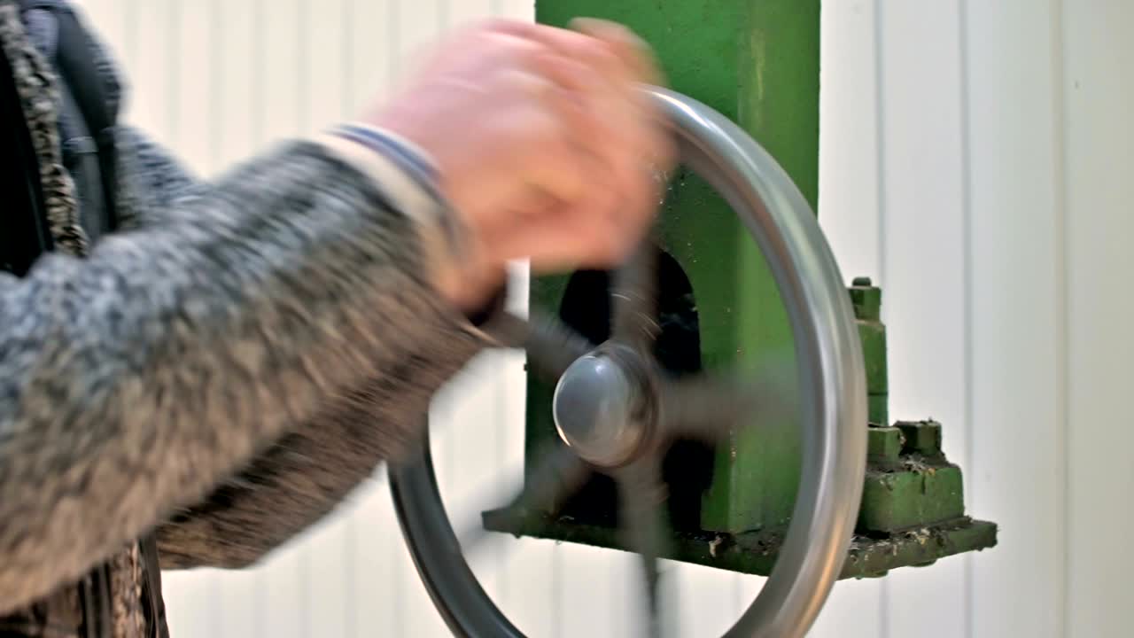 손의 클로즈업: 남성 연구원이 태양 관측소의  잎의 개방 메커니즘의 수동 바를 회전시니다.