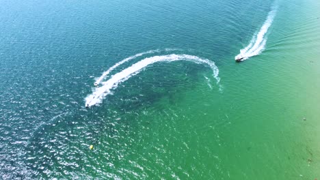 4K-drone-clip-of-boats-and-jet-skis-performing-water-sports-next-to-an-exotic-beach-in-Sveti-Vlas,-Bulgaria