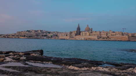 a time lapse shot of a coastal cityscape from twilight with bright city lights to dawn