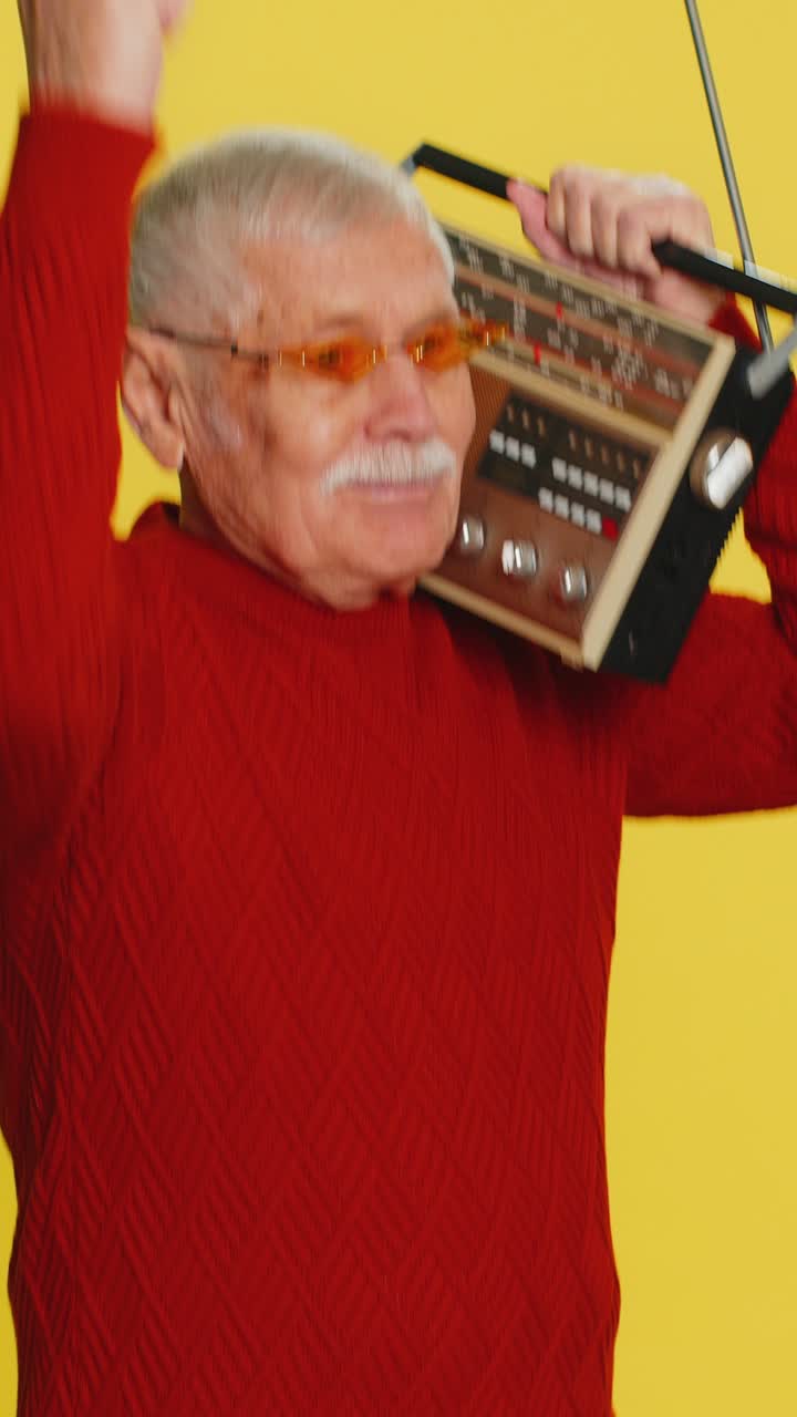 Happy old man listen music on retro tape record player disco dancing fan of vintage technologies