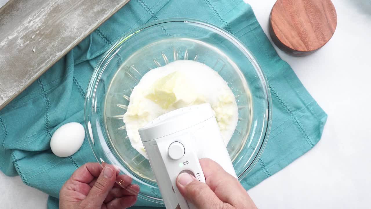 Making a dessert called Red Raspberry Tea Cake made with fresh berries and vanilla buttercream frosting. Great for Tea Parties. Using a white hand held mixer to beat in the unsalted butter