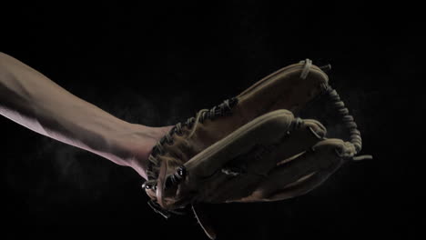 close up of baseball catching baseball in slow motion with back background