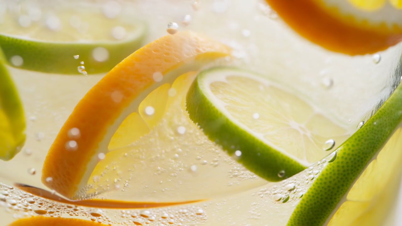 Closeup Citrus Slices In Sparkling Water Showing Lime And Orange Wedges Suspended In Effervescent Bubbles,