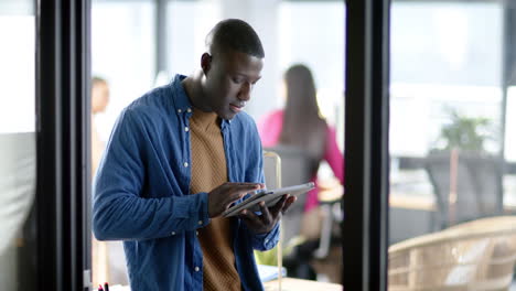 African-american-businessman-using-tablet-in-office,-slow-motion,-copy-space