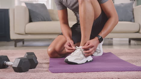 primer plano de un hombre con ropa de fitness en casa sujetando zapatillas antes de hacer ejercicio - filmado en cámara lenta