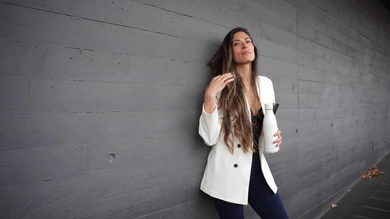 Una giovane donna che si prende una pausa caffè rilassante mentre si gode un moderno ambiente urbano.