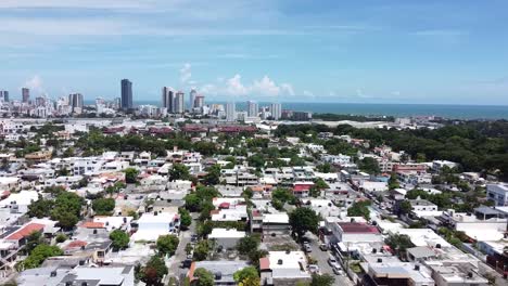 Drone-flying-over-residential-suburbs-with-the-background-of-the-capital-city-with-big-buildings