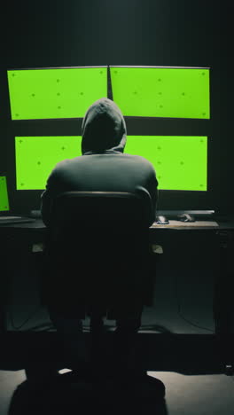 hacker at work with green screen monitors