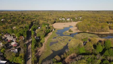 aerial tilt down from beautiful nature landscape to hingham train track, america