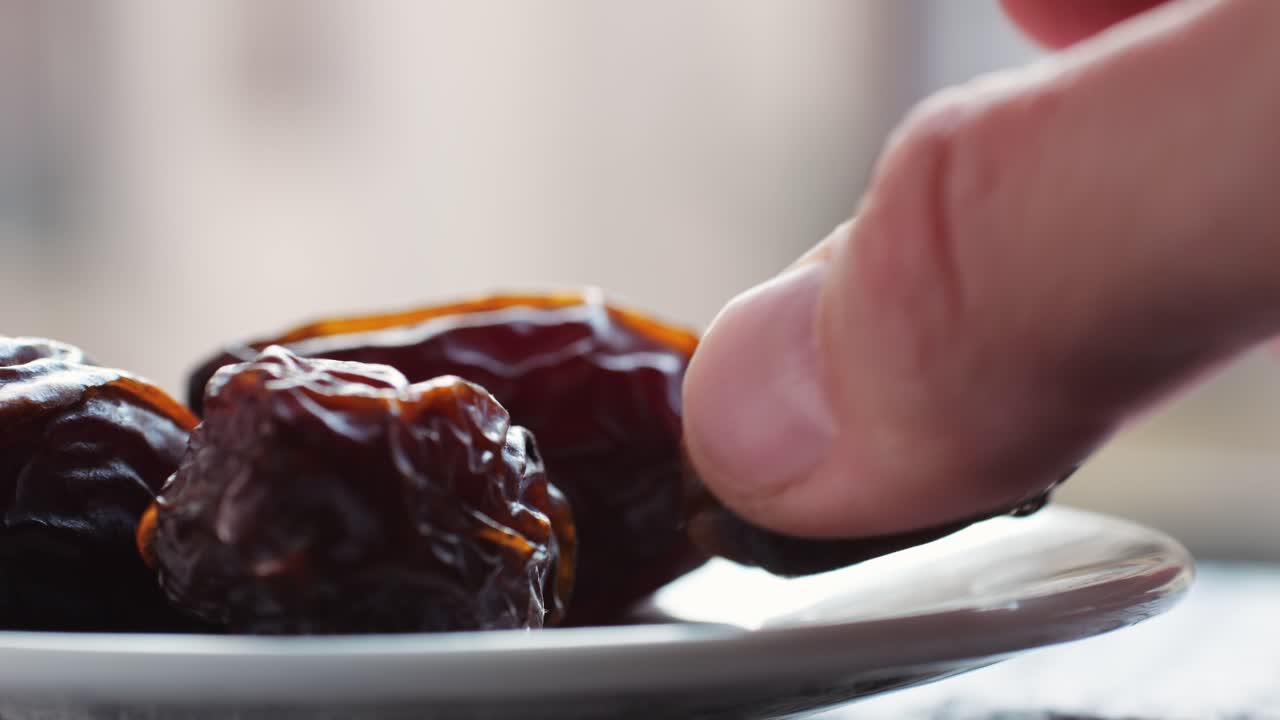 Hand picking dates from a plate
