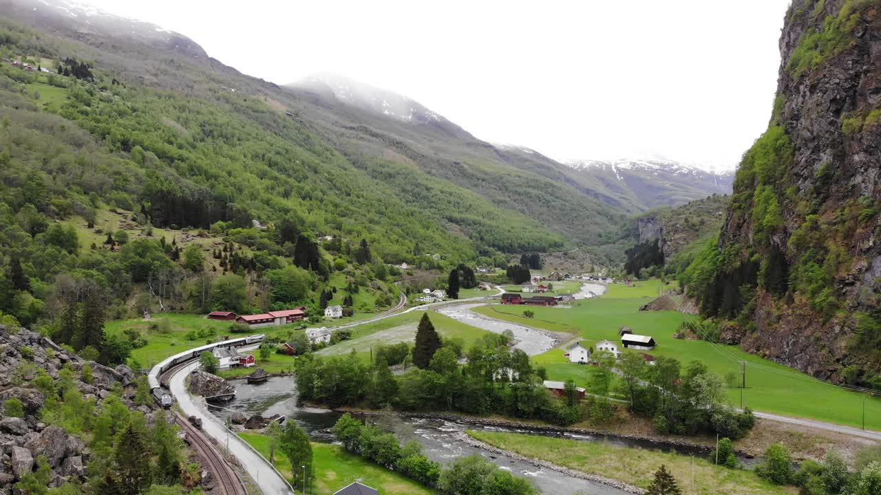 antena: tren flåm atravesando un valle entre verdes prados