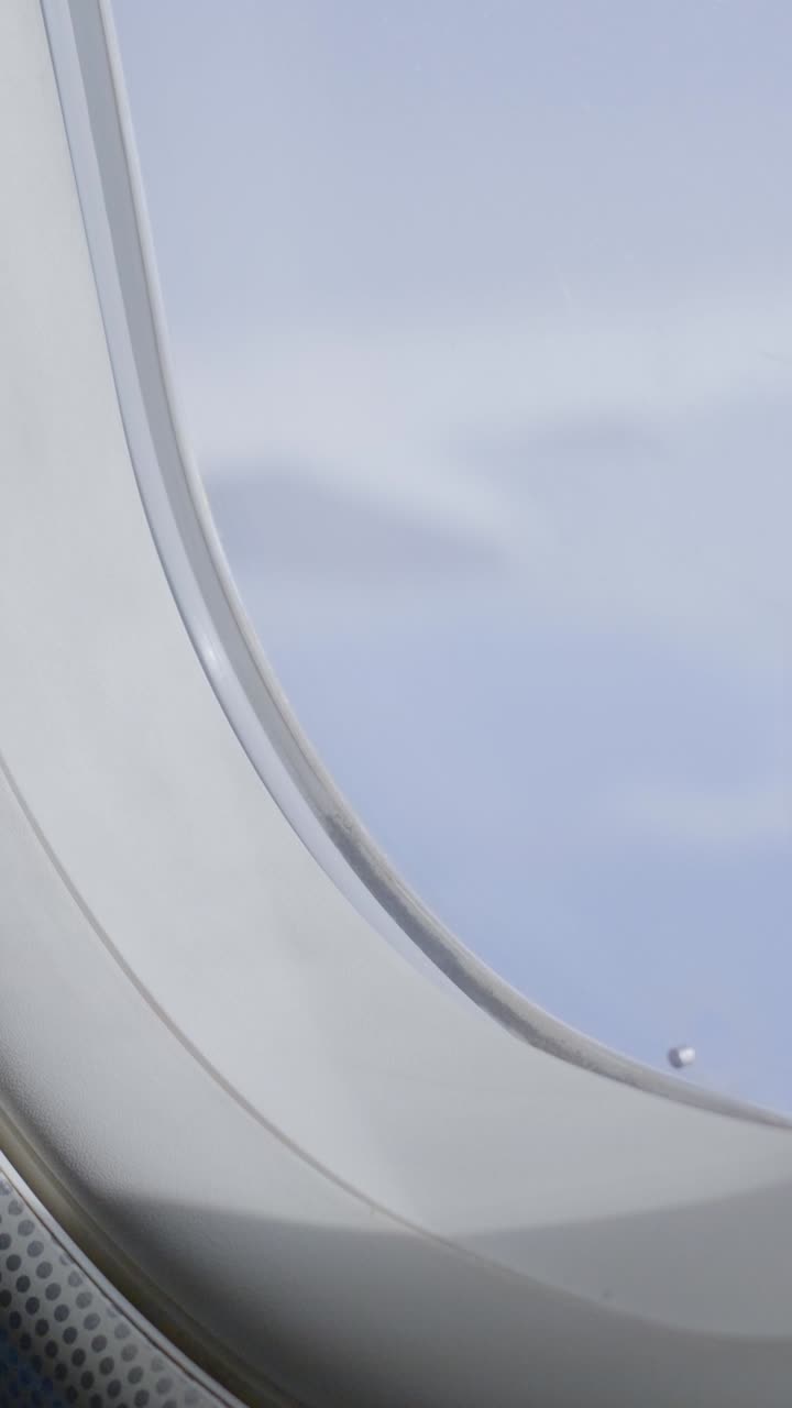 View from airplane window of clouds drifting by, peaceful and serene