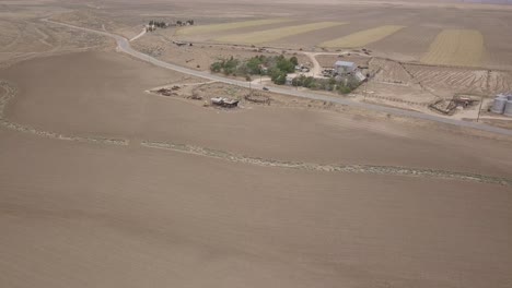 Aerial-drone-Footage-of-a-barn-on-open-field-in-Lancaster,-CA