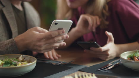 couple dining and using smartphones