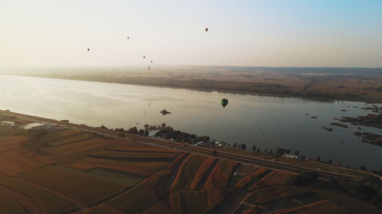 Stunning 4K aerial footage of a drone filming hot air balloons. Flying over farming fields and river. Filmed on a beautiful summer morning. Part of a hot air ballon festival in Prelog, Croatia.