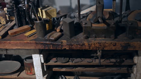 un taller de fabricación de zapatos de zapatero vintage con herramientas y calzado