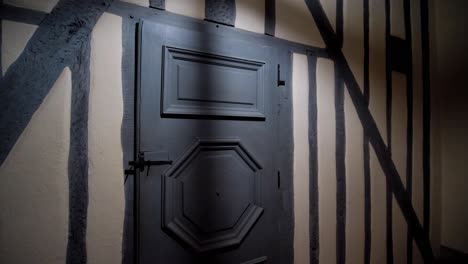 Dimly-Lit-Gray-Door-in-an-Attic-with-Low-Ceiling-Light