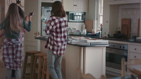 happy-teenage-girls-dancing-in-kitchen-eating-pizza-having-fun-celebrating-together-enjoying-hanging-out-together-on-weekend