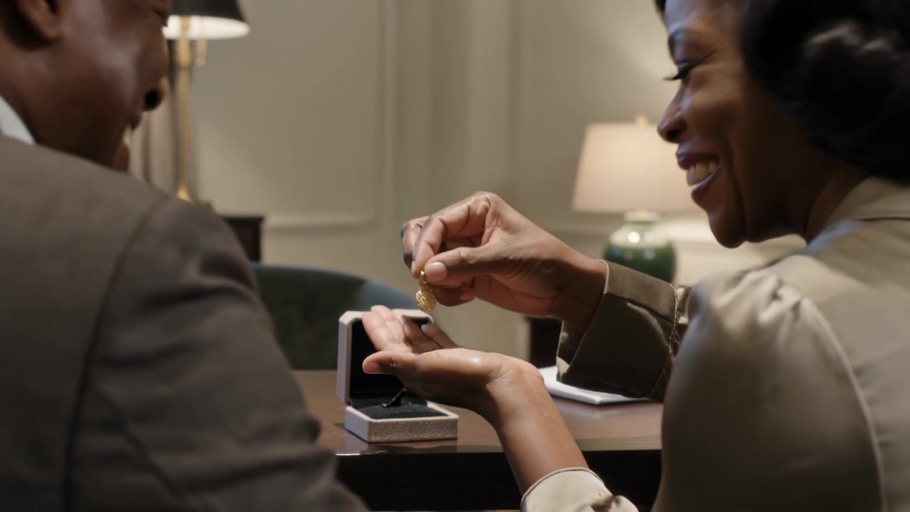 Placing white jewelry box, woman in blouse in office opening it, lifting gold pendant for gift