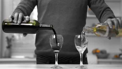 man pouring red and white wine into two glasses