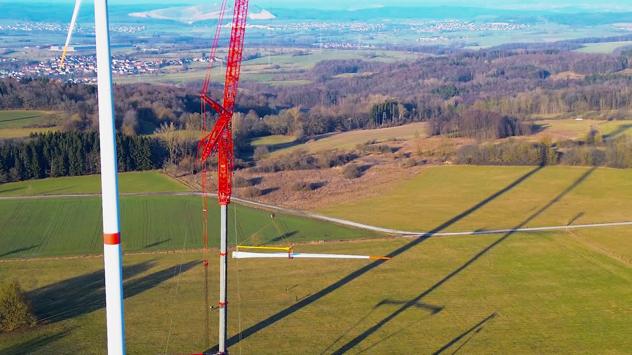 Luftfoto af tæt på vindmøllevinge, der installeres med kran i det landlige Tyskland