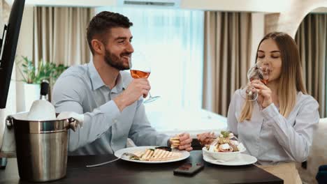 una pareja de negocios en un almuerzo en una habitación de hotel.