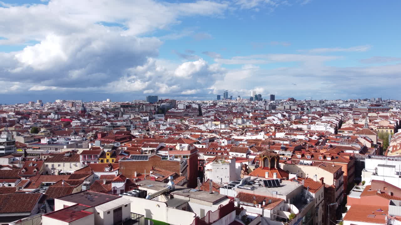Aerial flying over Madrid on sunny day, modern buildings in background