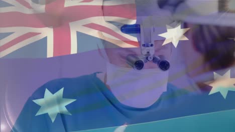 animation of australian flag over caucasian doctor using magnifying glass and performing surgery