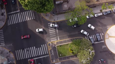 Aufsteigen-Aus-Der-Luft-Von-Oben-Nach-Unten-Von-Autos,-Die-Tagsüber-In-Der-Stadt-Buenos-Aires-Um-Die-Ecke-Fahren---4K-Drohnenaufnahme