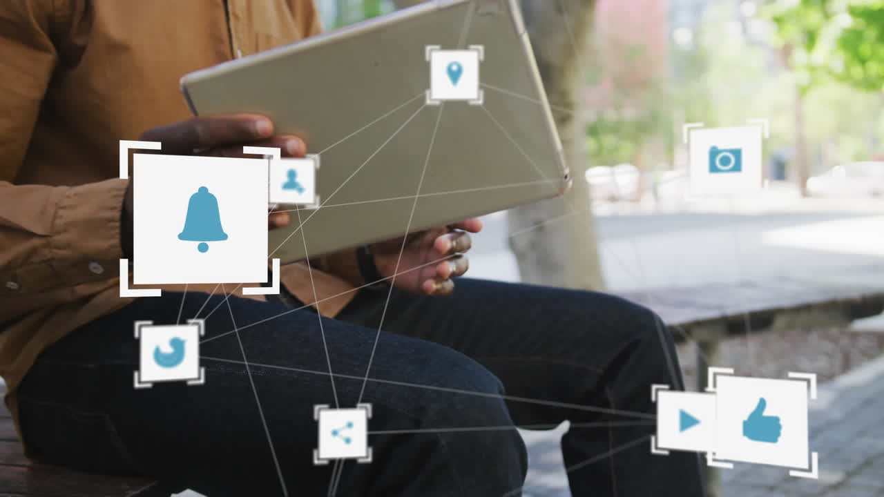 red de múltiples iconos digitales contra la sección media del hombre usando tableta digital en la calle