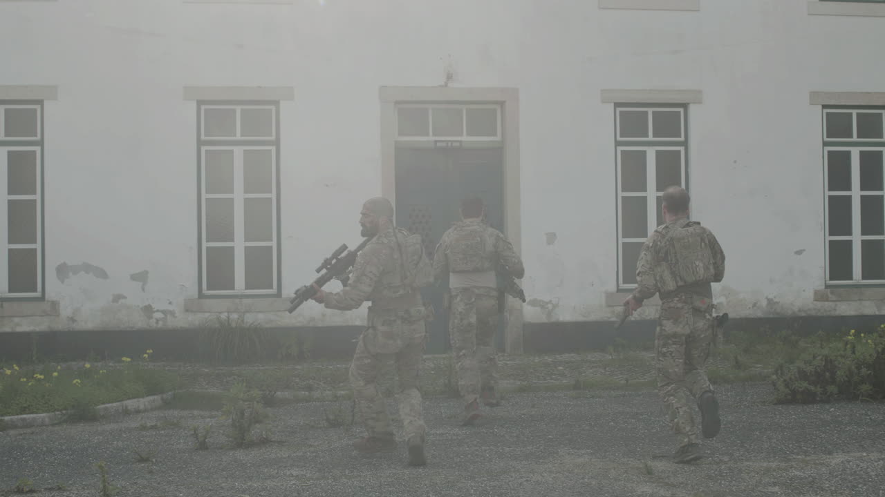 건물을 습격하는 소총을 든 군인의 뒷모습