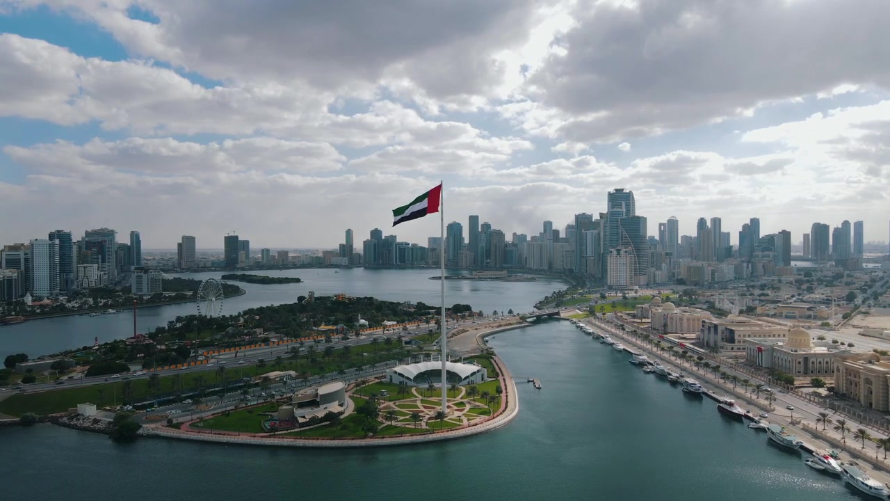 The UAE flag waves prominently over Sharjah, symbolizing national pride.