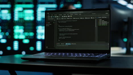 Focus on laptop used by engineers coding in modern data center