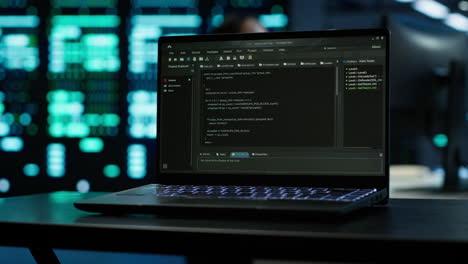 focus on laptop used by engineers coding in modern data center
