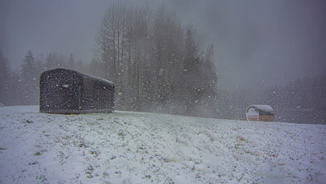 winter timelapse cabin and barrel landscape during december snow storm scene view