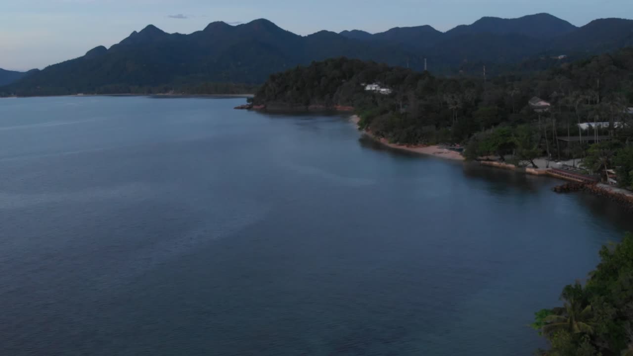 Drone shot flying along the coastline of Thailand, capturing the turquoise ocean, sandy beaches, and coastal scenery from above