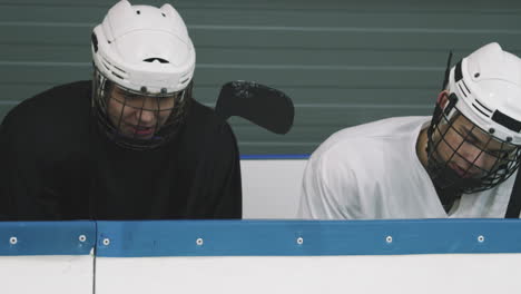 hockey players sitting on tribune talking