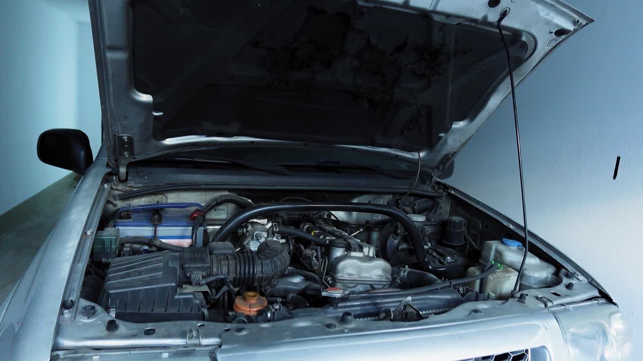 Car with Open Hood Showing Exposed Engine Outdoors