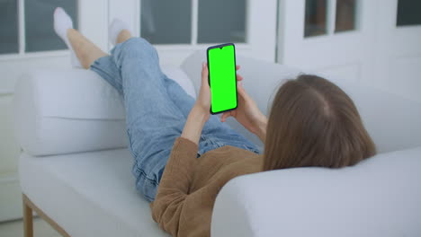 Nahaufnahme-Eines-Greenscreen-Vorlagen-Smartphones-In-Frauenhänden-Zu-Hause.-Mädchen-Schaut-Sich-Inhalte-An,-Ohne-Den-Gadget-Bildschirm-Zu-Berühren.-Modernes-Technologie--Und-Informationskonzept.