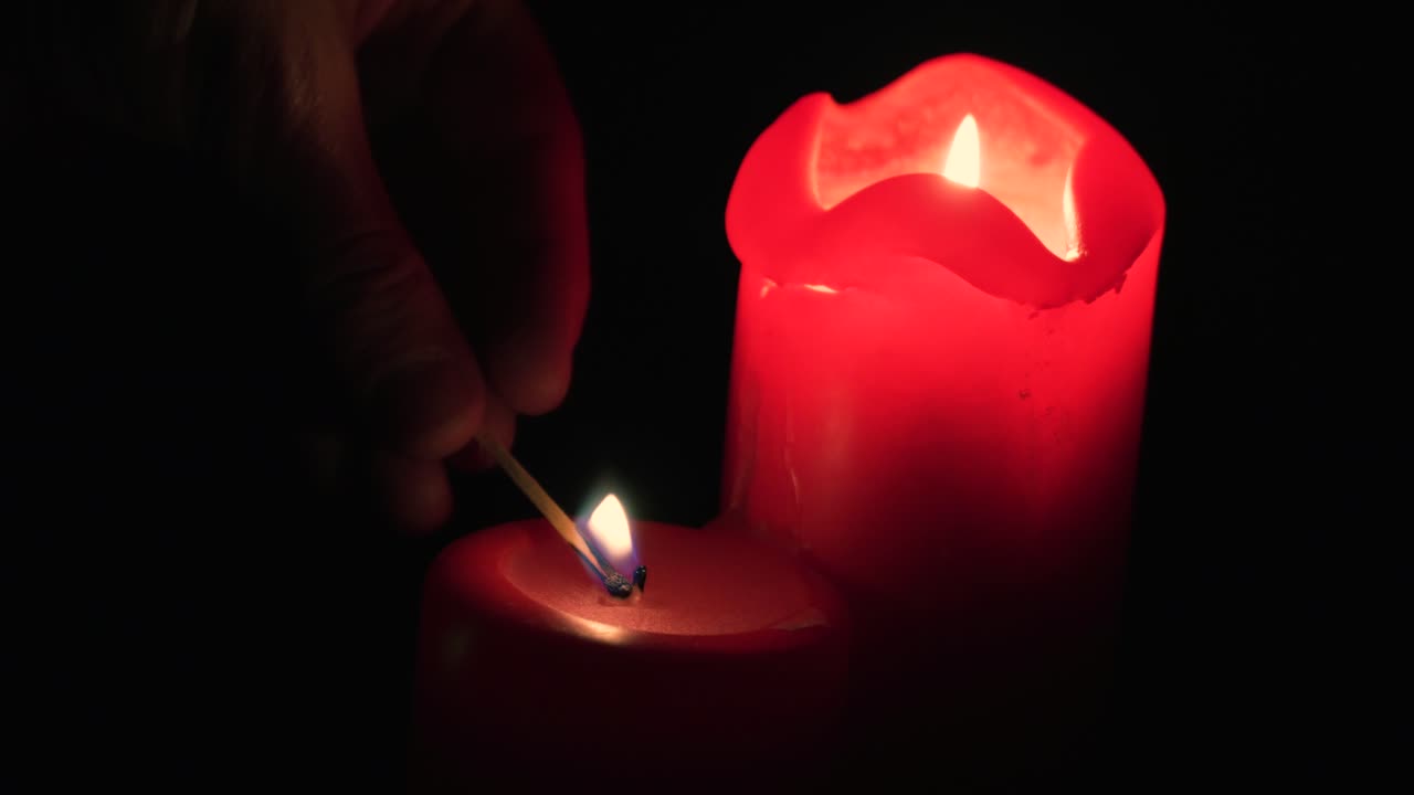hombre encendiendo velas en la oscuridad