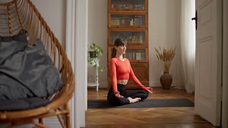 woman meditating in a yoga pose at home