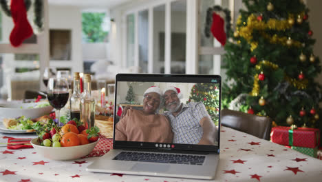 Felices-Abuelos-Afroamericanos-En-Una-Computadora-Portátil-Tumbados-En-La-Mesa-De-Navidad