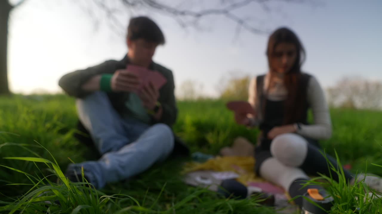 Couple playing cards in a park