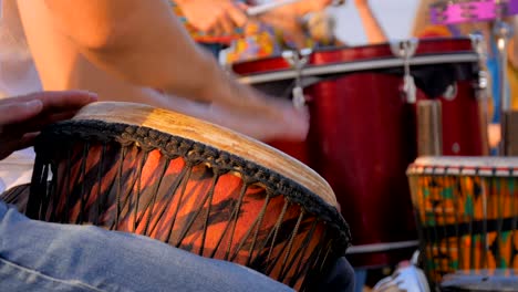 group of people playing ethnic drums on street