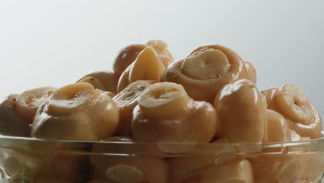 fermented champignons, jar with marinated mushrooms on wooden table, traditional salted marinated asian food.