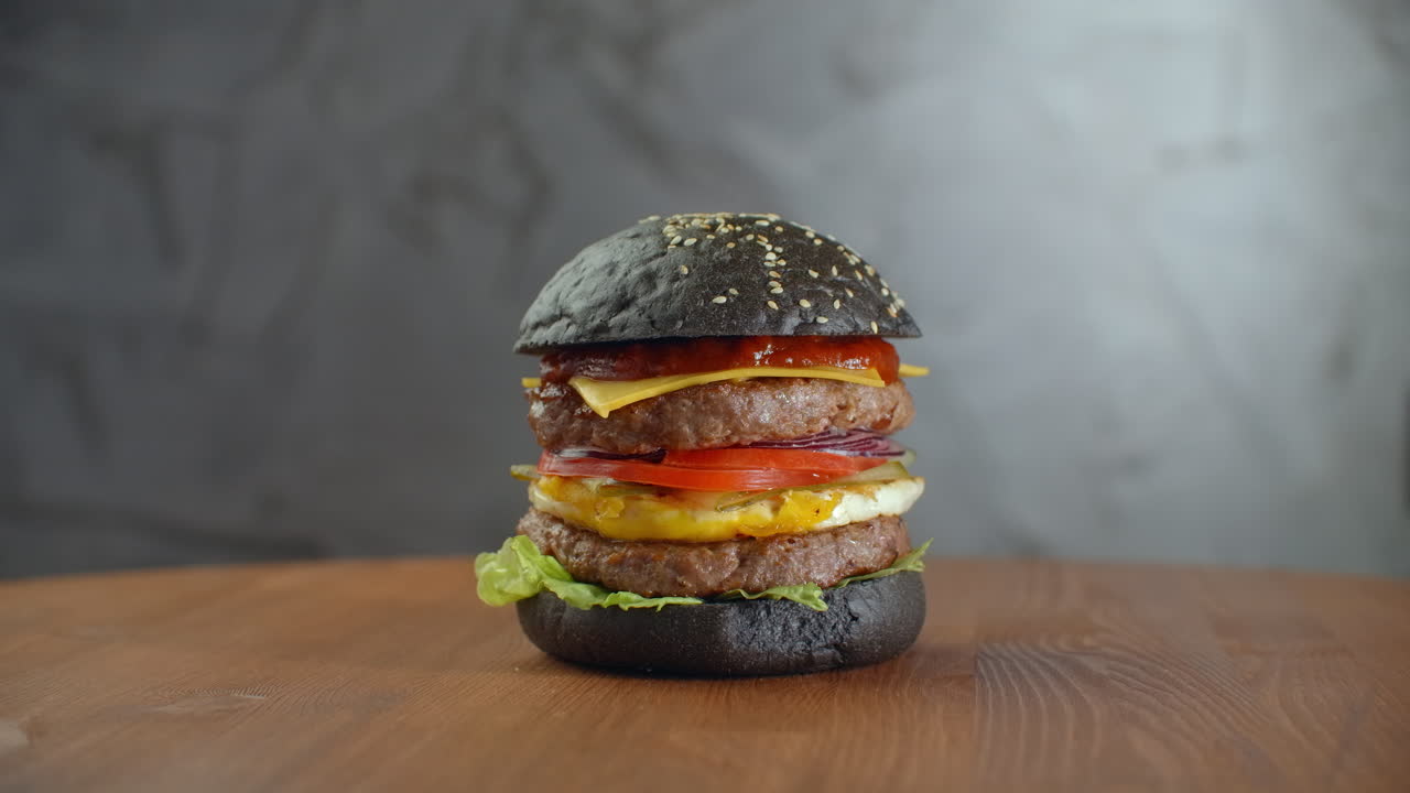 Premium stock video Black burger. a burger with a black roll slices